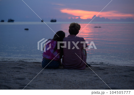 Couple of young lovers sitting on beautiful beach in Thailand 104505777