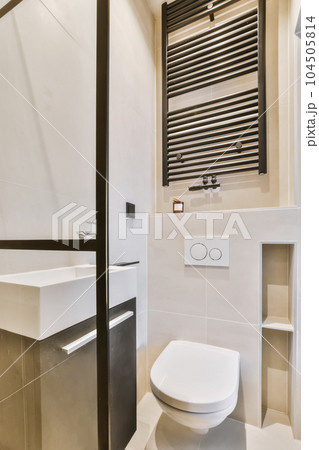 a modern bathroom with black and white tiles on the walls, toilet, sink, and towel rack in it a modern bathroom with black and white tiles on the walls, toilet, sink, and towel rack in it 104505814