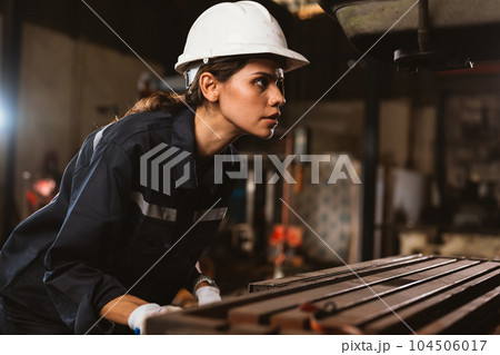 Confident female technician engineer worker checking and inspecting machine Confident female technician engineer worker checking and inspecting machine 104506017