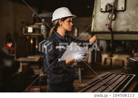Confident female technician engineer worker checking and inspecting machine 104506113