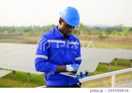 Engineer worker checking and maintaining solar panels on solar farm 104506616