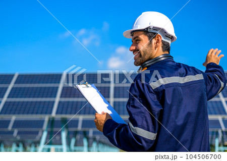 Engineer worker portrait with solar panel at solar farm 104506700