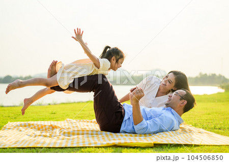 Happy family relaxing and resting in park together on weekend Happy family relaxing and resting in park together on weekend 104506850