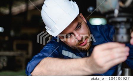 Professional male technician checking and repairing machinery Professional male technician checking and repairing machinery 104506927