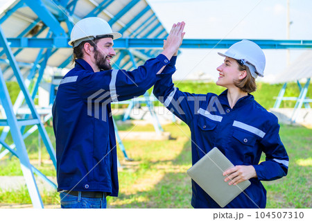 Maintenance worker team working with success at solar panel farm 104507310