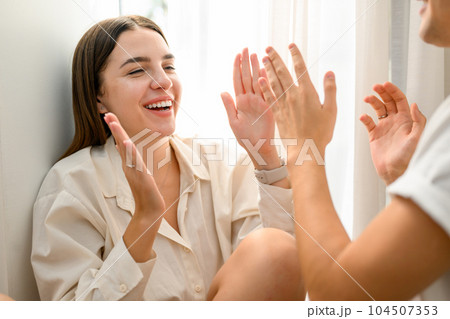 Couple of happy young people spending time together at home on weekend Couple of happy young people spending time together at home on weekend 104507353
