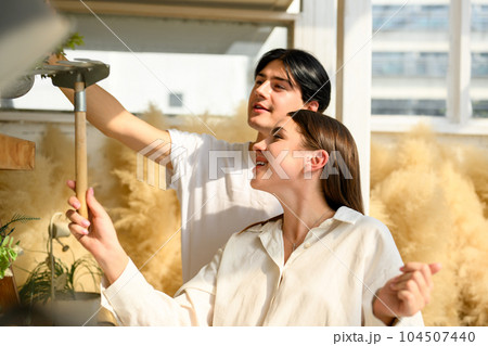 Couple of happy young people spending time together at home on weekend Couple of happy young people spending time together at home on weekend 104507440