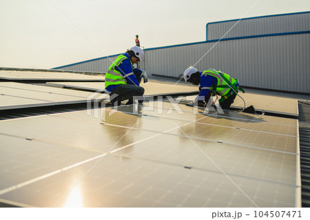 Maintenance technicians installing solar panels at solar cell farm Maintenance technicians installing solar panels at solar cell farm 104507471
