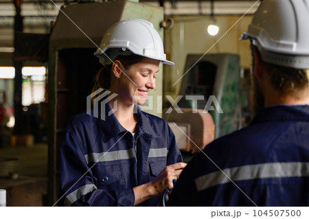 Mechanical engineers repairing engine machine at factory 104507500