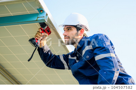 Male technician worker installing solar panels at solar cell farm 104507582