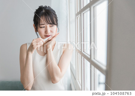 虫歯が痛い・しみて頬を押さえるアジア人女性 104508763