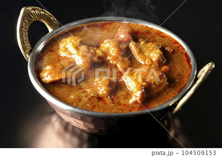 鶏肉入りスパイシー熱々インドカレーを黒背景で撮影 104509153