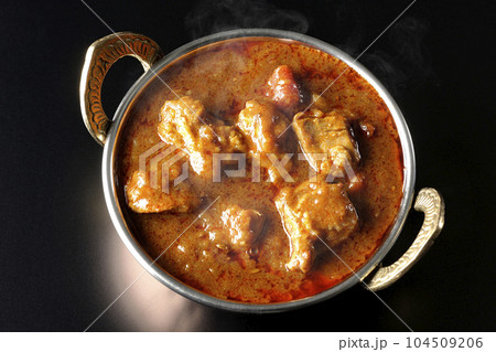 鶏肉入りスパイシー熱々インドカレーを黒背景で俯瞰撮影 鶏肉入りスパイシー熱々インドカレーを黒背景で俯瞰撮影 104509206