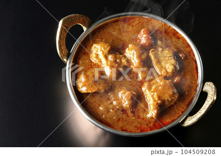 鶏肉入りスパイシー熱々インドカレーを黒背景で俯瞰撮影 104509208