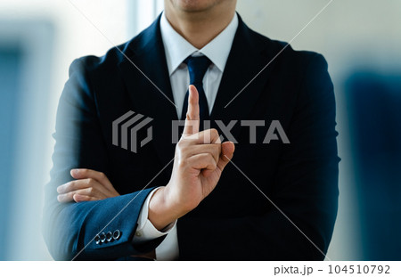人差し指を立てるビジネスマン 104510792