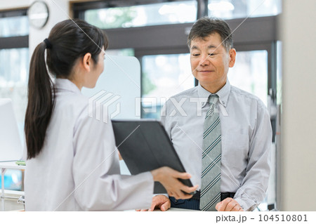 薬局でタブレットPCを使いながら説明する薬剤師・調剤師(レセコン・レセプトコンピュータ) 薬局でタブレットPCを使いながら説明する薬剤師・調剤師(レセコン・レセプトコンピュータ) 104510801