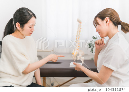 整骨院・接骨院で骨盤の病気の診察・相談・カウンセリングする整体師・マッサージ師の女性（困る・悩む） 104511874