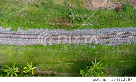 Aerial view of the railway in the park. Top view of the railroad from a drone. Train tracks in rural scene Aerial view of the railway in the park. Top view of the railroad from a drone. Train tracks in rural scene 104512267