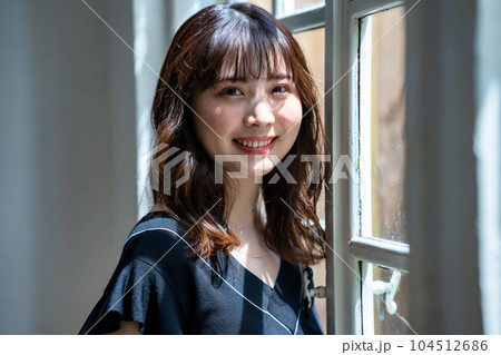 窓際に立つフェミニンな雰囲気の女性 104512686