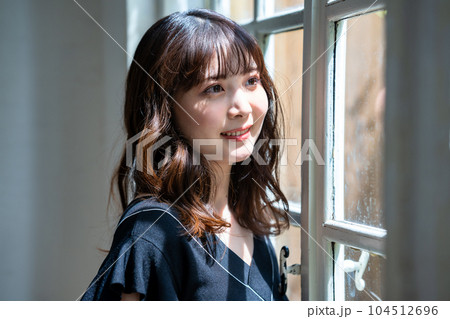 窓際に立つフェミニンな雰囲気の女性 104512696