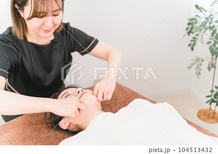 小顔矯正・造顔・コルギ（骨気）・フェイスマッサージの施術をするセラピストの女性（エラ） 104513432