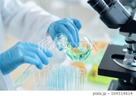 試験管を使って研究開発をする白衣の研究者 試験管を使って研究開発をする白衣の研究者 104514614