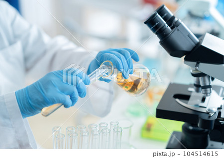 試験管を使って研究開発をする白衣の研究者 試験管を使って研究開発をする白衣の研究者 104514615
