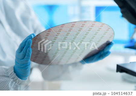 クリーンルームでウェハーを検査するエンジニア 104514637