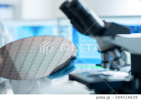 クリーンルームでウェハーを検査するエンジニア 104514639
