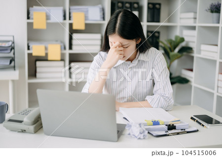 Asian business woman is stressed, bored, and overthinking from working on a tablet at the modern office. Asian business woman is stressed, bored, and overthinking from working on a tablet at the modern office. 104515006