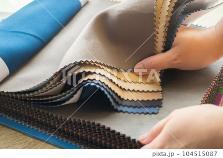 female designer with fabric color samples choosing textile for curtains 104515087