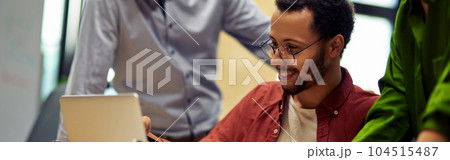 Group of focused multiracial business people looking at laptop screen and discussing work or project results while standing in the modern office or coworking space Group of focused multiracial business people looking at laptop screen and discussing work or project results while standing in the modern office or coworking space 104515487
