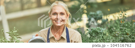 Middle aged caucasian business woman watering plants Middle aged caucasian business woman watering plants 104516762