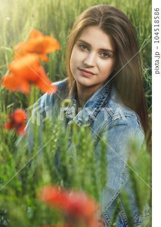 Portrait of beautiful girl dressed in jeans sitting in cornfield. Portrait of beautiful girl dressed in jeans sitting in cornfield. 104518586