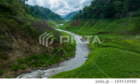 Aerial view tropical green forest and river with mountains in background, Green tree forest view from above river and forest. Aerial view tropical green forest and river with mountains in background, Green tree forest view from above river and forest. 104519560