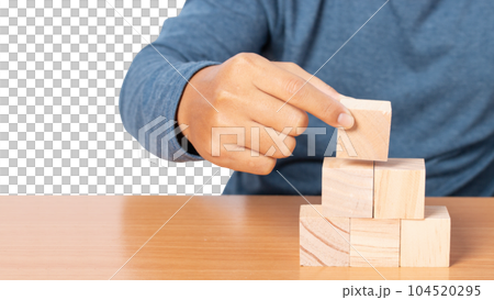Young man stacking wooden blocks. Young man stacking wooden blocks. 104520295