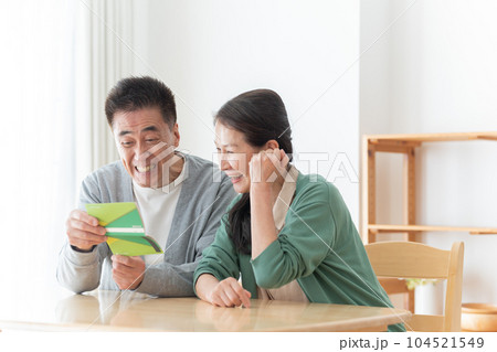 通帳を見るシニア夫婦 通帳を見るシニア夫婦 104521549