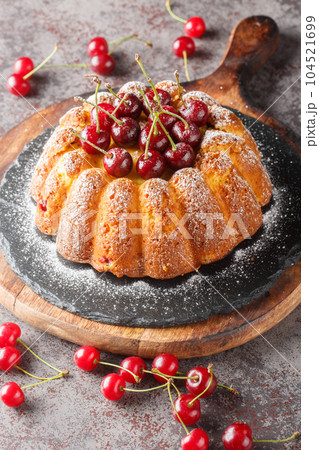 Freshly baked cherry cake close-up on a wooden board. Vertical 104521699
