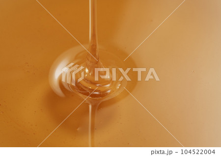 Closeup shot of organic honey pouring in bowl Closeup shot of organic honey pouring in bowl 104522004