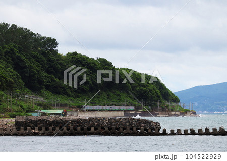 石狩湾の海岸沿いを走るJR函館本線の列車　銭函駅付近 104522929
