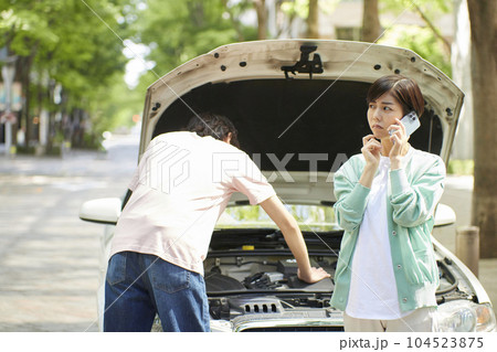 車の故障で電話をする若い女性 車の故障で電話をする若い女性 104523875