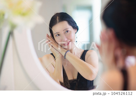 Young Asian woman looking in the mirror. 104526112