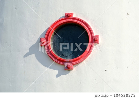 A round window with red edges. Lighthouse on the Estonian island of Kihnu A round window with red edges. Lighthouse on the Estonian island of Kihnu 104528575
