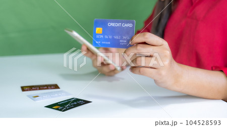 Young consumer woman holding mock up credit card, Ready to spending pay online shopping according to discount products via smartphone and laptop from home 104528593