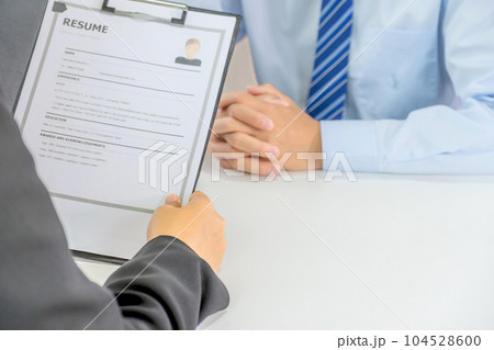Office executives hand holding resume and interviewing job applicants in the meeting room. employer conversation summary work employment Office executives hand holding resume and interviewing job applicants in the meeting room. employer conversation summary work employment 104528600