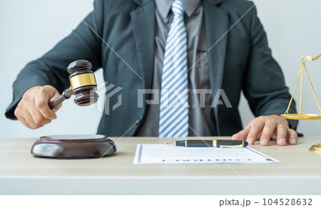 Lawyer hand holding gavel hammer hit and providing legal consult business dispute service to the man at the office with justice scale 104528632
