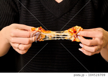 Female hands breaking savory baked bread roll with cheese 104528709