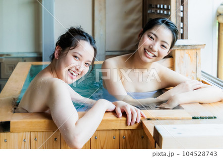 のんびり檜風呂に入る若い女性達 104528743