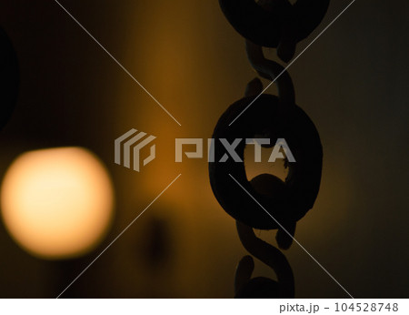 Dark silhouette of links on the background of a luminous lamp Dark silhouette of links on the background of a luminous lamp 104528748