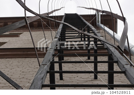 Metal staircase on the wall of apartment house Metal staircase on the wall of apartment house 104528911